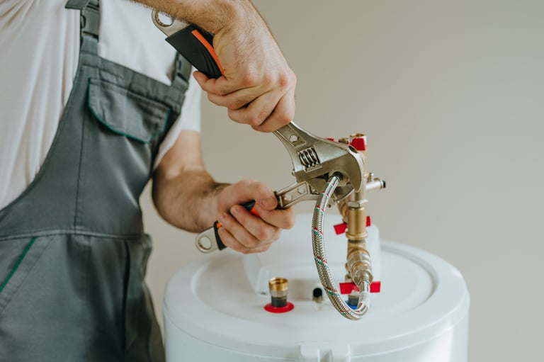 Professional plumber fixing water heater with wrench