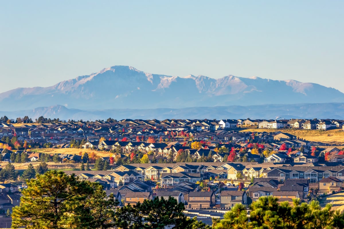 Residential neighborhood of post-war homes with a mountain range view in the distance
