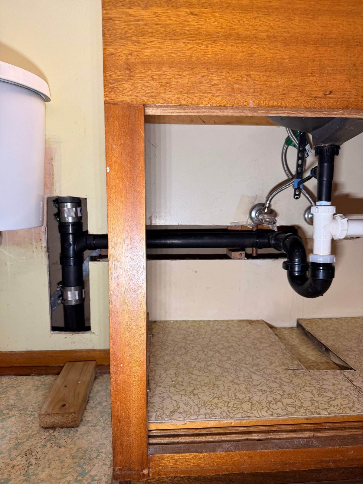 Under-sink plumbing with P-trap and water supply lines installed beneath bathroom or kitchen cabinet